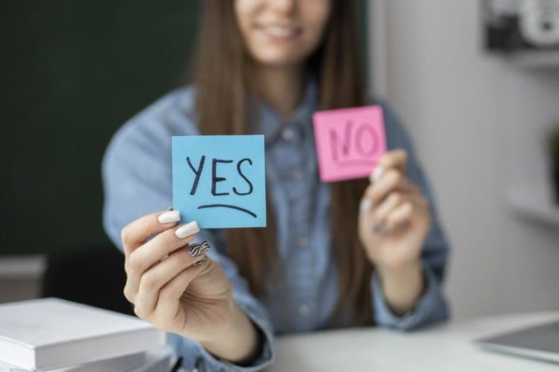 woman holding post it note yes