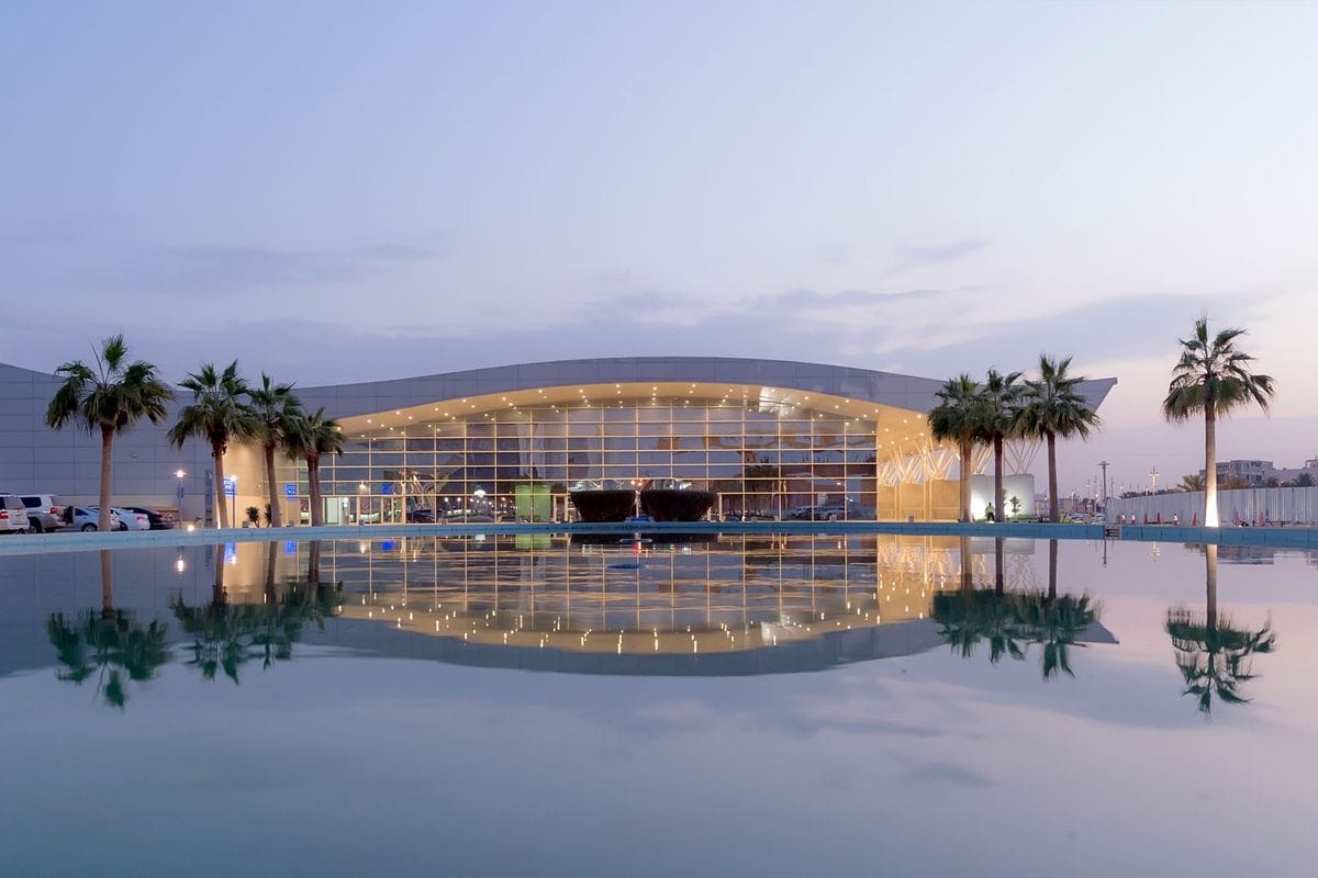 Modern glass conference centre with a pool in front