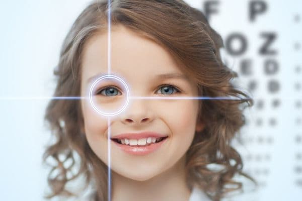 young girl smiling with a laser like beam circling her eye