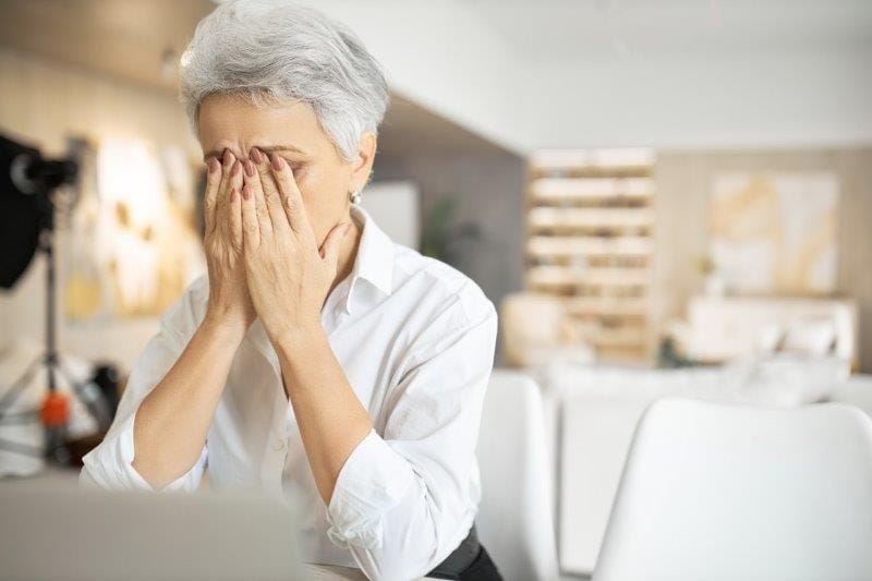 senior sad woman stress rubbing eyes small